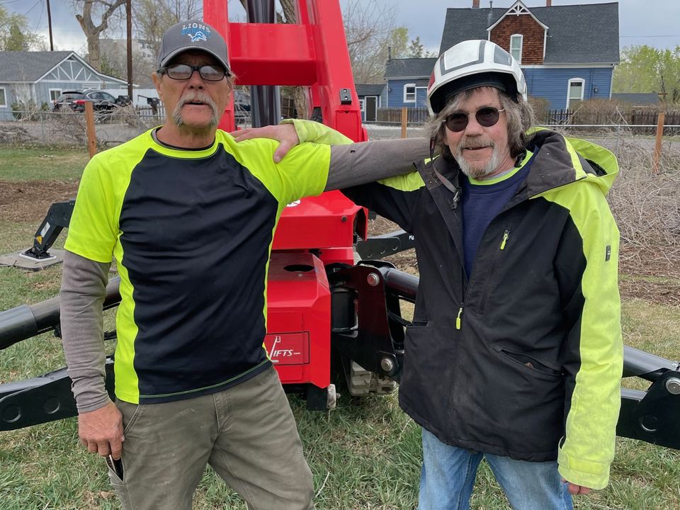 Two Arbor Pro arborists standing beside their truck